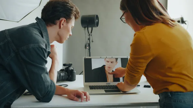 Two photographers review a portrait on a laptop during a studio session. An outlook on how tighter review enforcement is reshaping the commerce reviews market
