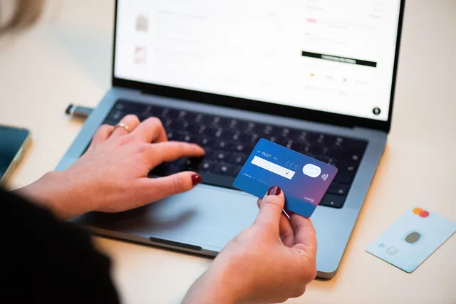 A person using a bank card to shop online. How to calculate ecommerce review ROI with an example